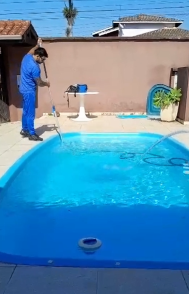 Piscineiro Rai aspirando piscina residencial